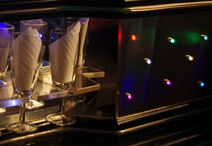 Mirrored bar area with colour lights and champagne flutes