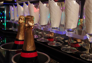 Two bottles in ice buckets with flutes and napkins